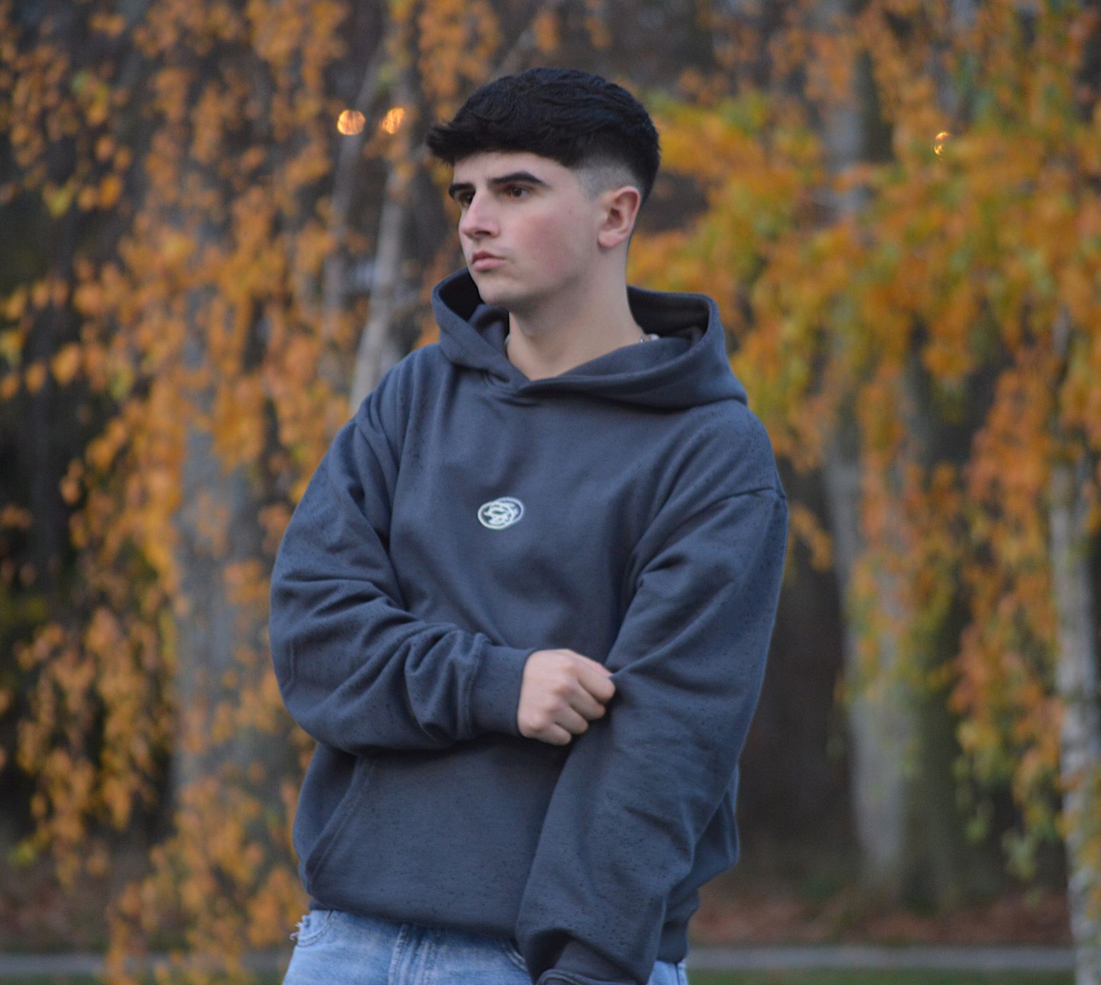 Modelo con la sudadera Star gris antracita entre árboles de otoño